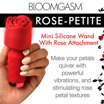 Hand holding a red mini silicone wand with a rose-shaped attachment, highlighting its textured petals and compact design.