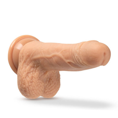 Realistic silicone dildo in vanilla color with suction cup base and detailed texture.
