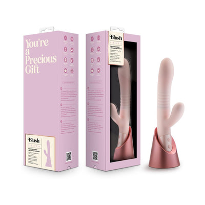 Blush Fraya Pink dual-stimulation vibrator with thrusting shaft and clitoral stimulator, displayed with packaging and rose gold charging stand.