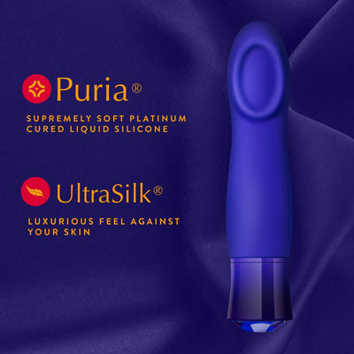 Sapphire blue vibrator with cupped tip on purple silk fabric, highlighting Puria silicone and UltraSilk luxurious texture features.
