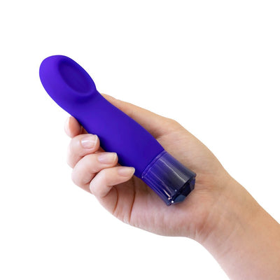 Hand holding a compact sapphire blue vibrator with a curved, cupped tip and faceted base.