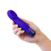Hand holding a compact sapphire blue vibrator with a curved, cupped tip and faceted base.