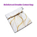 White cotton drawstring bag with gold wavy line pattern and Blush brand tag, folded on white background.