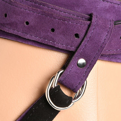 Close-up of purple suede leather corset harness strap with silver metal buckle and black strap detail.