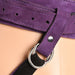 Close-up of purple suede leather corset harness strap with silver metal buckle and black strap detail.