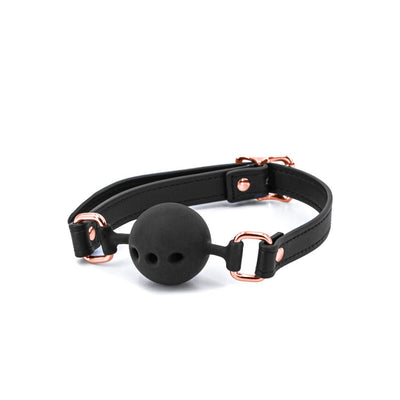 Black silicone ball gag with adjustable black PU strap and rose gold metal hardware on white background.