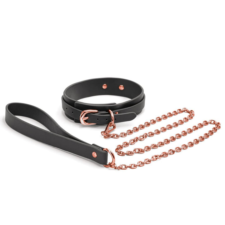 Black synthetic collar with rose gold buckle and matching rose gold chain leash with black handle loop on white background.