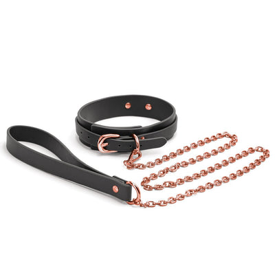 Black synthetic collar with rose gold buckle and matching rose gold chain leash with black handle loop on white background.