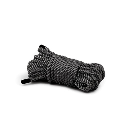 Coiled black synthetic bondage rope with a smooth, twisted texture, designed for comfort and durability.
