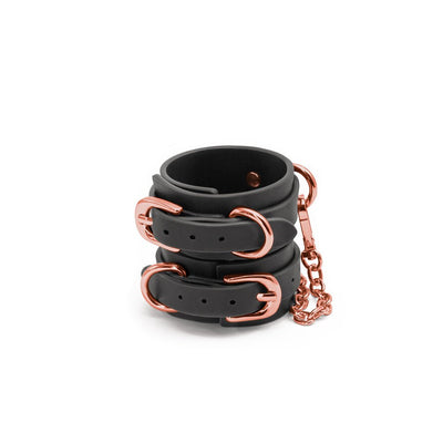 Black synthetic wrist cuffs with rose gold buckles and chain detail, designed for comfort and style.