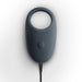 Dark gray vibrating cock ring with power button and charging cable on white background.