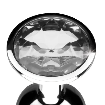 Small metal anal plug with a clear faceted gem at the base, polished silver finish, elegant tapered design.