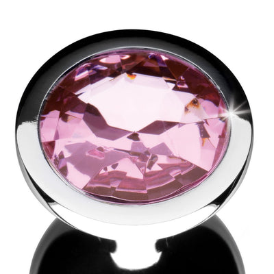 Close-up of a silver anal plug base featuring a large, faceted pink gem with a reflective shine.