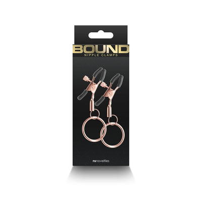 Rose gold adjustable nipple clamps with black silicone tips and rings, displayed in black packaging with gold lettering.