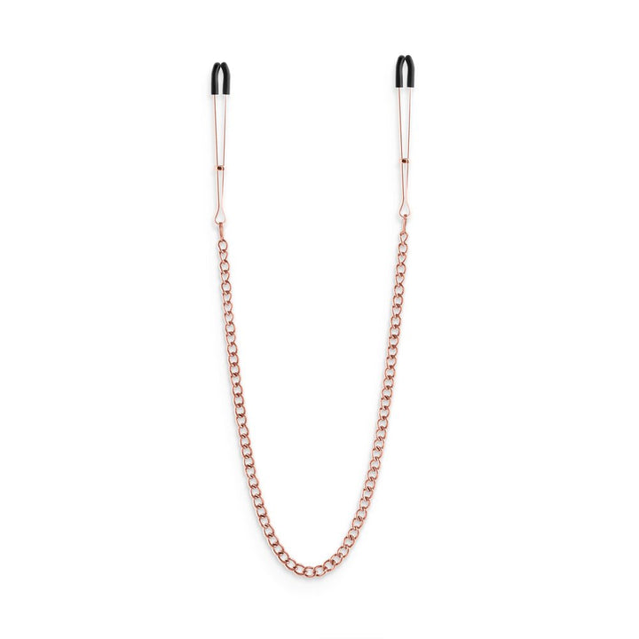 Rose gold adjustable nipple clamps connected by a matching chain with black silicone tips for comfort.