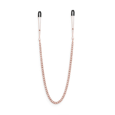 Rose gold adjustable nipple clamps connected by a matching chain with black silicone tips for comfort.