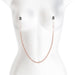 Rose gold adjustable nipple clamps with black silicone tips connected by a matching chain on a white mannequin torso.