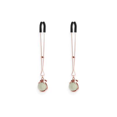 Pair of rose gold adjustable nipple clamps with black silicone tips and decorative round accents.