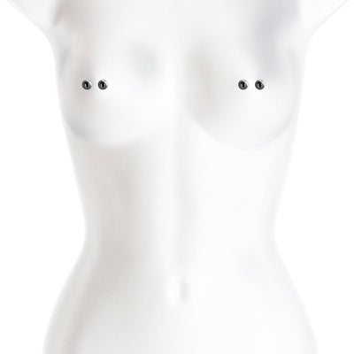 White mannequin torso displaying a pair of gunmetal-colored nipple clamps with smooth rounded tips.