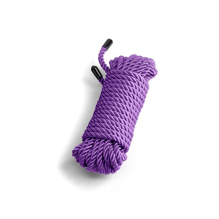 Coiled purple soft rope with black capped ends on white background, designed for comfortable and creative use.