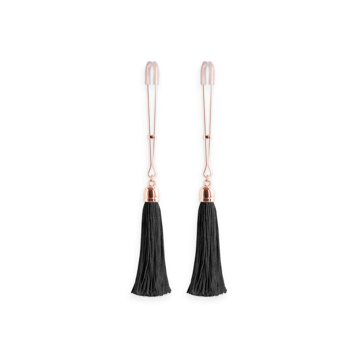 Pair of rose gold adjustable nipple clamps with soft silicone tips and black tassel accents on a white background.