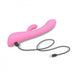 Pink dual stimulator with curved design and clitoral arm, shown with USB charging cable on white background.