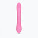 Pink sleek dual stimulator with ergonomic design and smooth silicone surface, standing upright on white background.