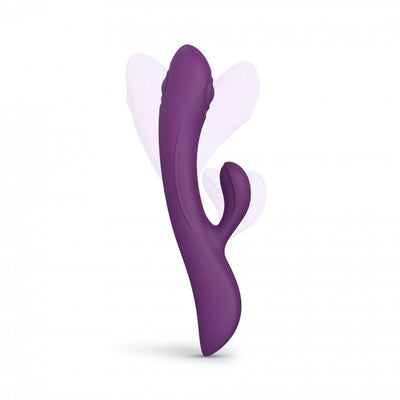 Purple dual stimulator with ergonomic curved design and flexible clitoral arm, shown with motion effect on white background.