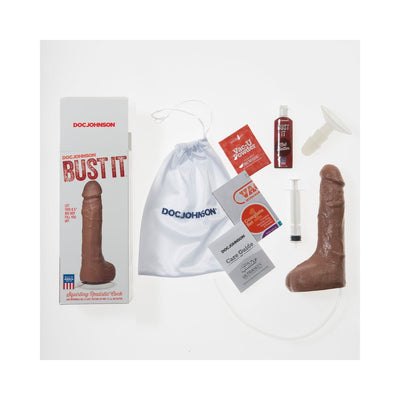 Realistic brown squirting dildo with suction base, packaging, care guide, nut butter, and accessories on white background.
