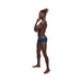 Male model wearing black and blue Casanova Uplift Mini Shorts in XL, standing in profile against white background.