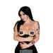 Woman wearing black censored bar pasties and a black corset with tattoos on her arms against a white background.