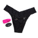 Black lace thong panty with pink wearable bullet vibrator and black wireless remote control on white background.
