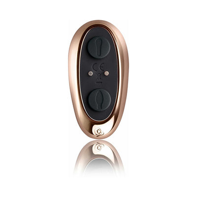 Rose gold and black remote control for couples' toy with two buttons and reflective surface below.