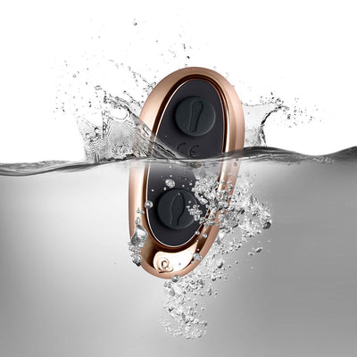 Rose gold and black waterproof remote control for couples toy submerged in water with bubbles.