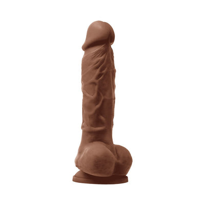 Realistic textured dildo in brown with a suction base for hands-free use, standing upright on a white background.