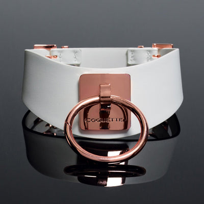 White vegan leather choker with rose gold metal ring and engraved Coquette plate on reflective black surface.