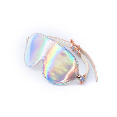 Holographic rainbow bondage blindfold with adjustable rose gold buckles on white background.