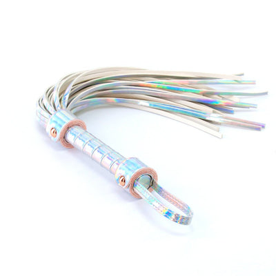 Rainbow holographic flogger with a textured handle and rose gold hardware accents on a white background.