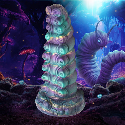Iridescent teal and purple fantasy caterpillar-inspired silicone toy with textured segments and suction cup base against a glowing forest background.