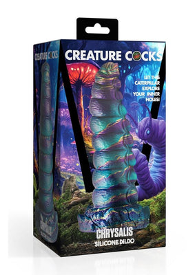 Packaging of Creature Cock Chrysalis silicone dildo with iridescent blue, purple, and gold caterpillar design against a fantasy forest background.