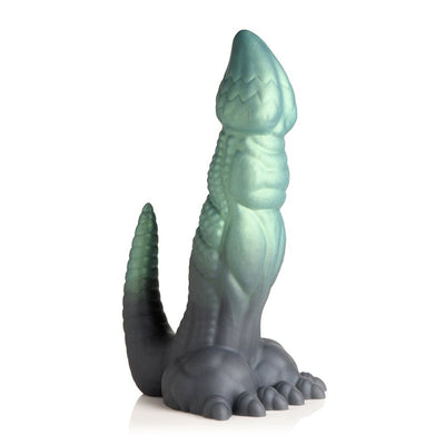 Green and black textured silicone fantasy dildo shaped like a dinosaur with clawed feet and a curved tail.