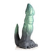 Green and black textured silicone fantasy dildo shaped like a dinosaur with clawed feet and a curved tail.