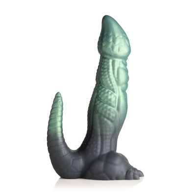 Green and black textured silicone dinosaur-themed adult toy with a curved tail and clawed feet base.