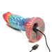 Rainbow-colored textured silicone dildo with suction base charging via USB cable on white background.