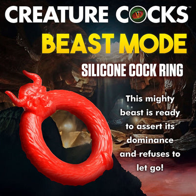 Red silicone cock ring with a horned beast design, featured against a dark cave background with bold yellow and white text.