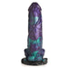 Blue, purple, teal, and black glittery silicone fantasy dildo with dinosaur legs and suction cup base, standing upright on white background.