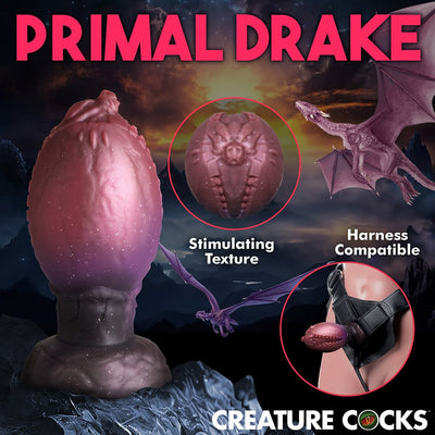 Large textured purple fantasy egg-shaped adult toy with dragon scale details, shown with harness compatibility and close-up texture view.