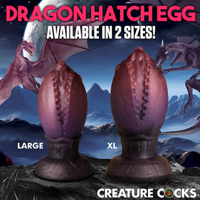 Two textured dragon egg-shaped plugs in large and XL sizes with a fantasy mountain and dragon background.