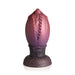 Large dragon egg-shaped plug in gradient red to purple silicone with textured ridges and glitter accents on a wide base.