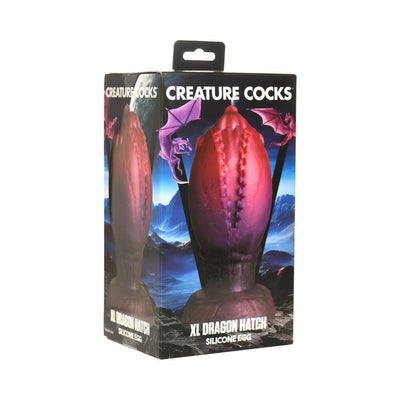 Packaging box of Creature Cocks XL Dragon Hatch silicone egg with dragon design and fantasy mountain background.